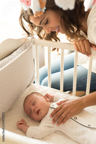 Mother putting baby to sleep