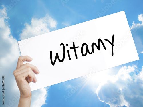 Witamy (Welcome in Polish) Sign on white paper. Man Hand Holding Paper with text. Isolated on sky background.