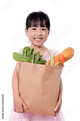 Asian little chinese girl carrying shopping bag with groceries