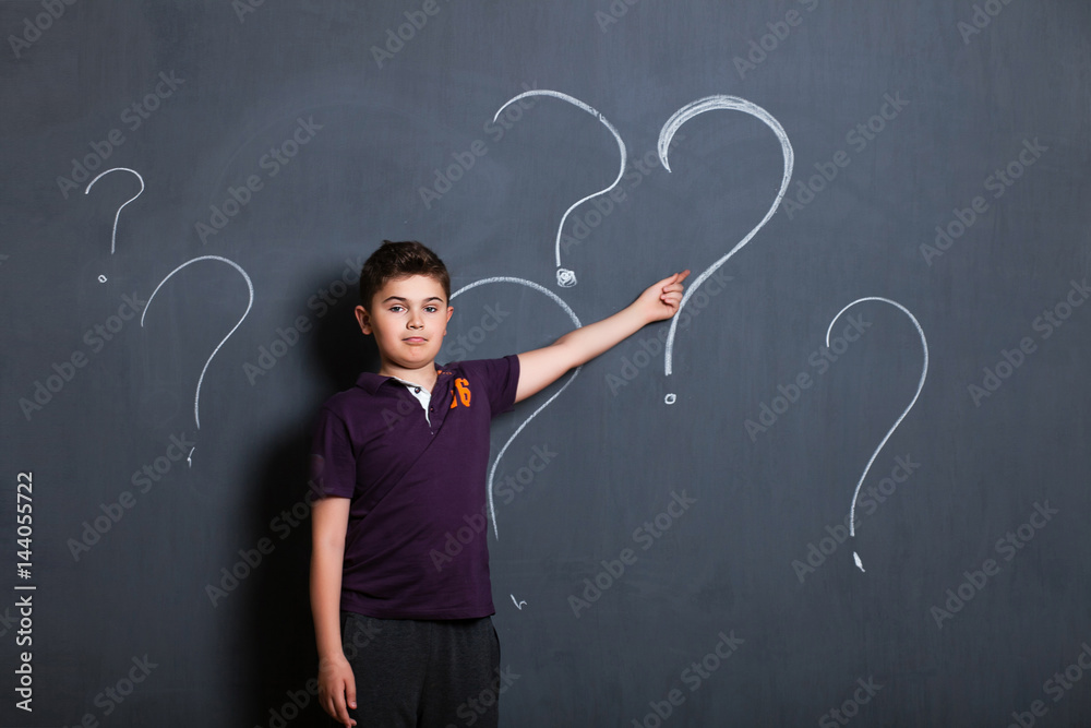 student boy beside a big blackboard for drawing, writing