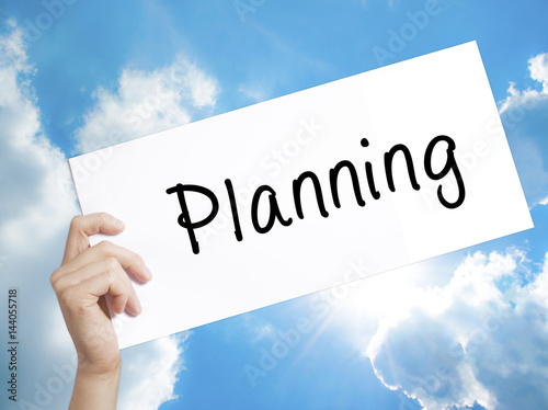 Planning Sign on white paper. Man Hand Holding Paper with text. Isolated on sky background
