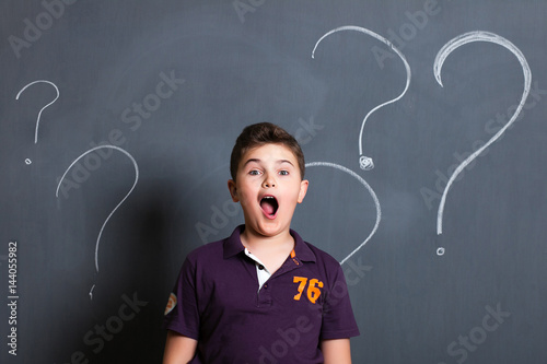 student boy beside a big blackboard for drawing, writing