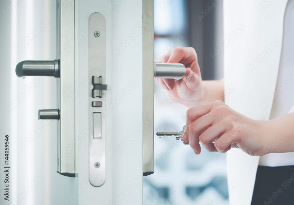 Fototapeta premium Locking or unlocking door with key in hand