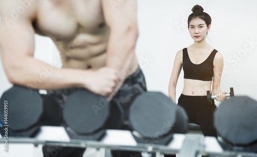 Asian People lifting dumbbells in gym. copy space.