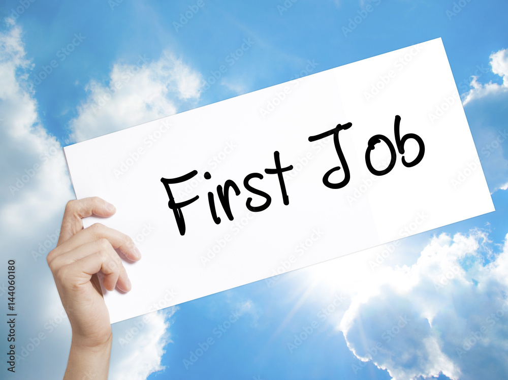 First Job Sign on white paper. Man Hand Holding Paper with text. Isolated on sky background First Job Sign on white paper. Man Hand Holding Paper with text. Isolated on sky background