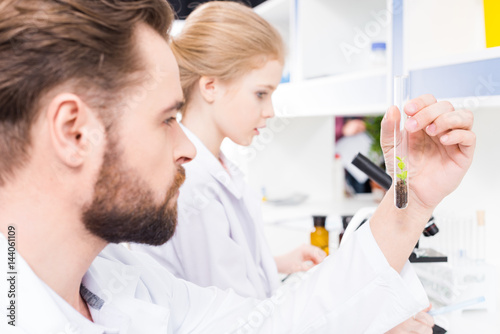 Side view of teacher and student scientists working together in laboratory