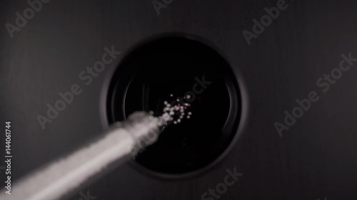 A poison from a test tube is poured into a glass of red wine. Slow motion, top view