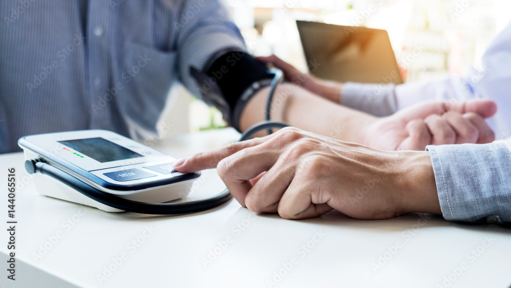 Fototapeta premium healthcare, hospital and medicine concept - doctor and patient measuring blood pressure