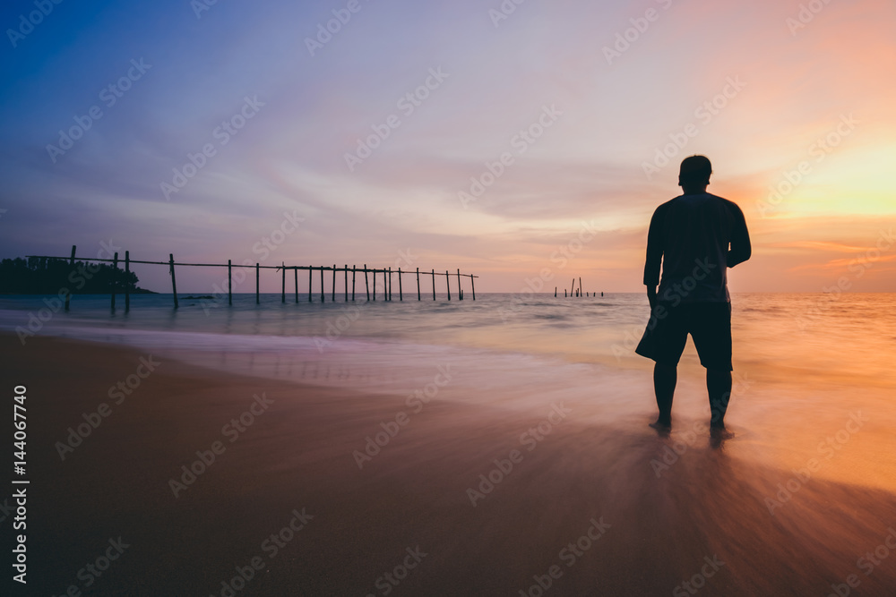 The silhouette of man standing alone at the beach, concept of lonely, sad, alone, person space, alone and scared