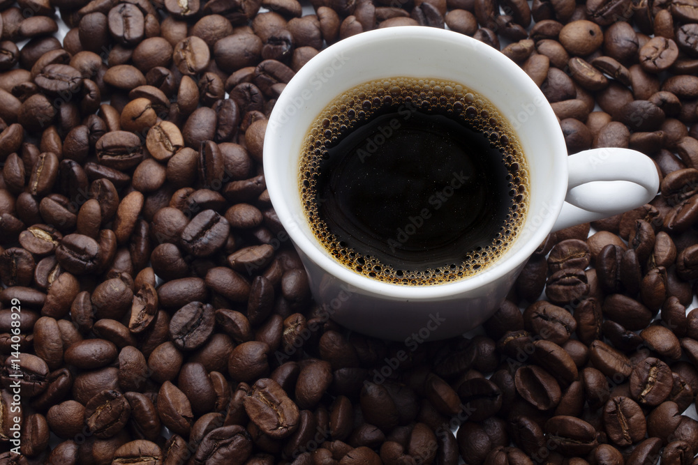 Cup and coffee over beans background Cup and coffee over beans background