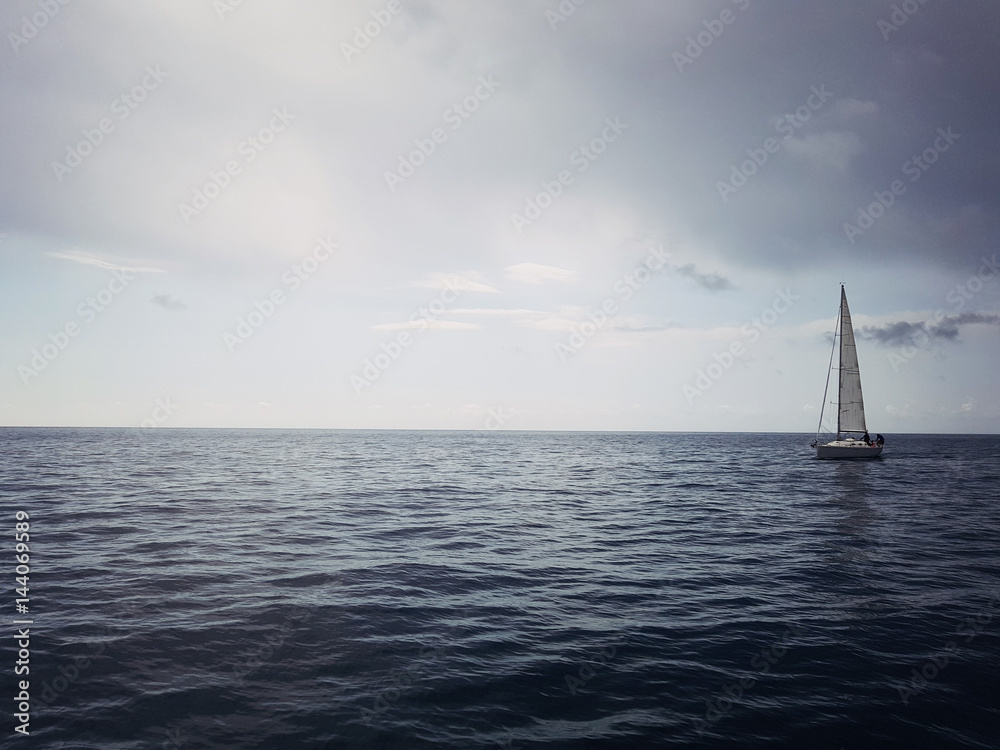 Obraz premium Yacht on the horizon in the blue sea