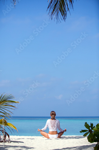 Young beautiful healthy woman making meditation on the beach © alexmalder
