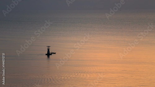 aerial view silhouette dawn lighthouse with way of life local fishery boat floating in the morning at Hua Hin, Thailand