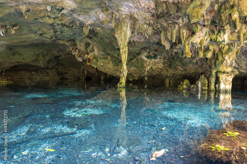 Fototapeta Naklejka Na Ścianę i Meble -  Bright blue cenote - underground waterhole in a lime stone cave. Tulum, Mexico.