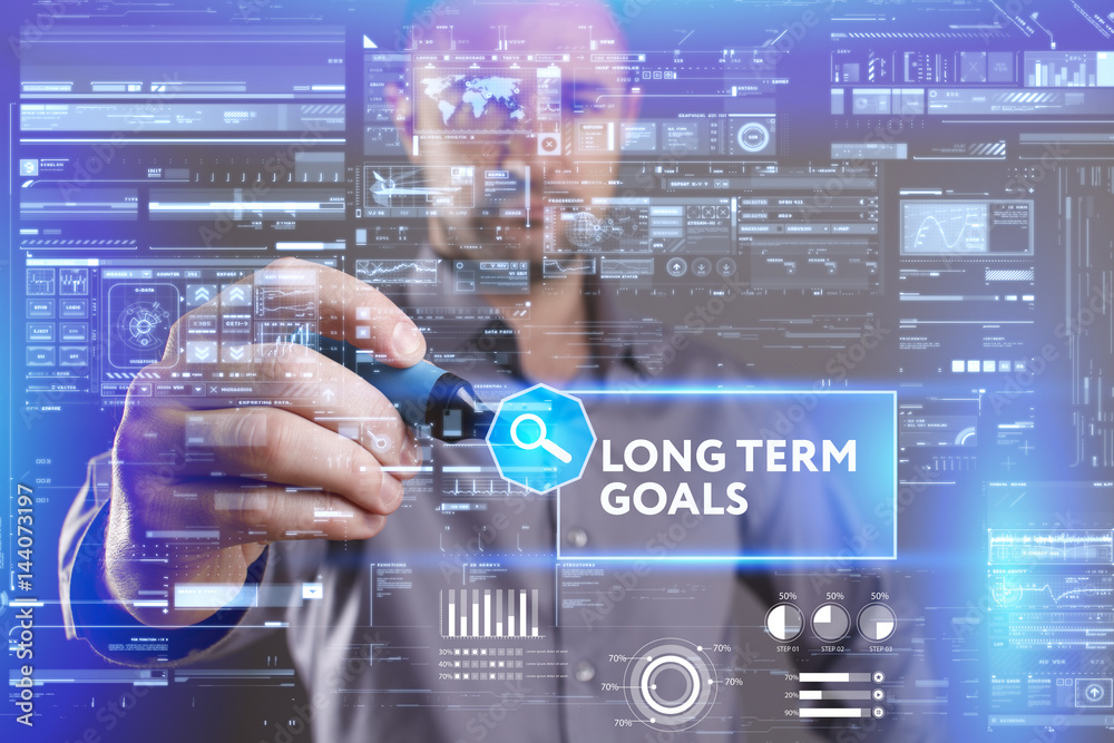 Business, Technology, Internet and network concept. Young businessman working on a virtual screen of the future and sees the inscription: Long term goals Business, Technology, Internet and network concept. Young businessman working on a virtual screen of the future and sees the inscription: Long term goals