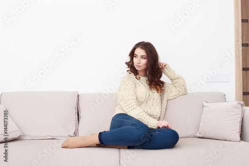 woman sitting on her white sofa