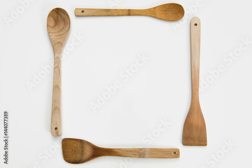 Wooden spoons arranged in a square on white background