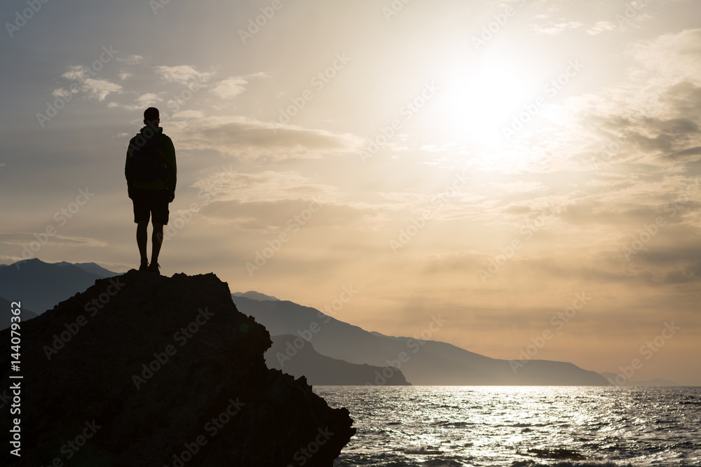 Hiking silhouette backpacker, man looking at ocean Hiking silhouette backpacker, man looking at ocean