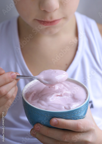 kid eating pink yogurt from the bowl