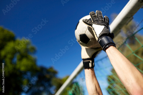 Fototapete goalkeeper with ball at football goal on field