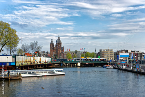 Canal boats and St Nicholas Church at Open Havenfront Amsterdam