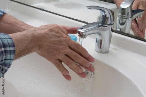 Hände am Waschbecken mit Wasser und Seife reinigen