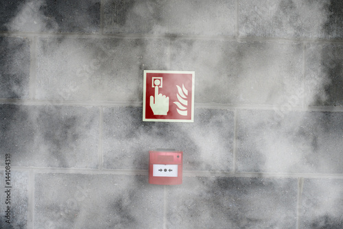 Emergency Fire Exit on the stone wall with fire  smoke