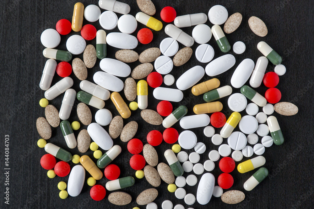 Bunch of various color pills on black background Bunch of various color pills on black background