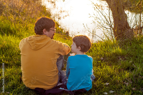 Father and son spend time together at the pond