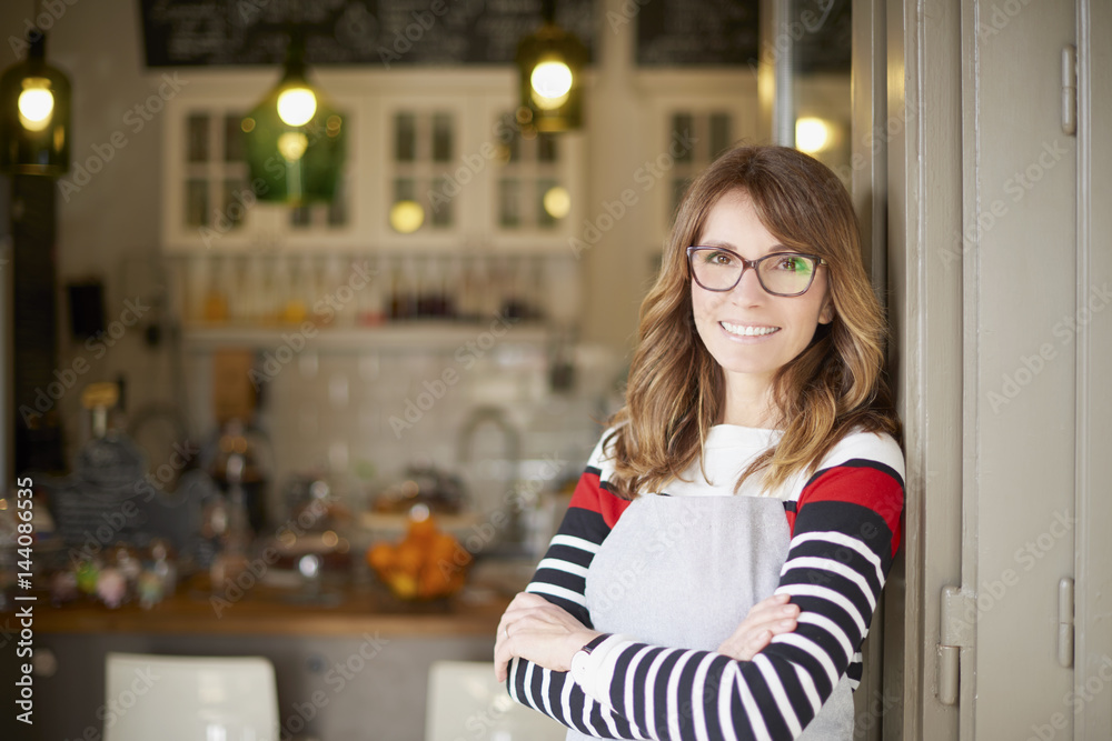 Proud cafe owner. Shot of a proud coffee shop owner businesswoman standing at doorway. Small business. Proud cafe owner. Shot of a proud coffee shop owner businesswoman standing at doorway. Small business.
