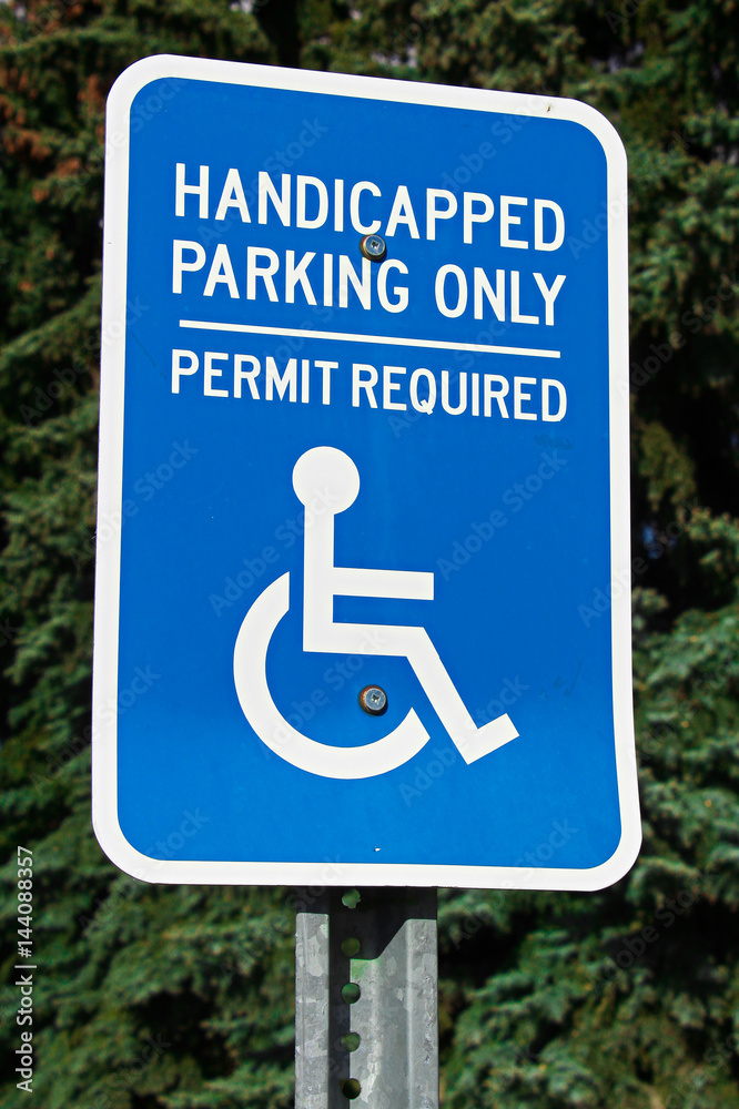 Handicap parking sign with trees in the background Handicap parking sign with trees in the background