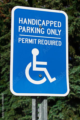Handicap parking sign with trees in the background