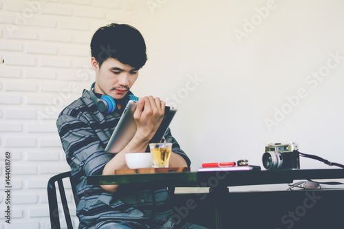 Young business man working with modern devices, digital tablet computer and smartphone