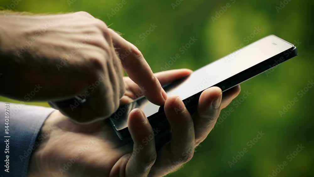Close-Up of Male Hand Using Smart Phone Outdoors in the Park