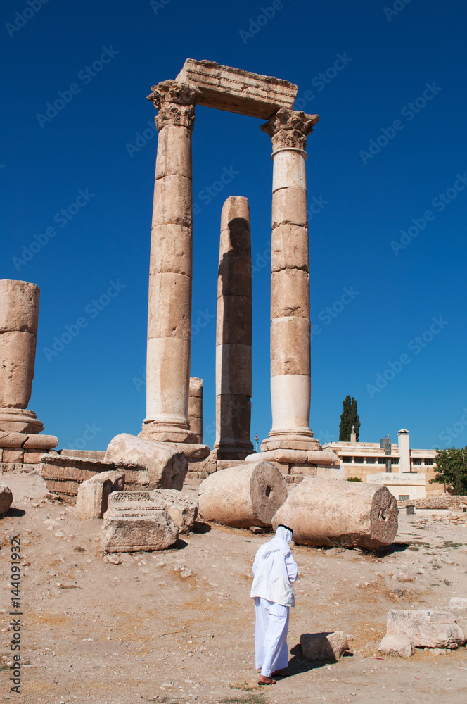 Giordania, 01/10/2013: un musulmano di spalle tra le rovine del Tempio di Ercole, la struttura romana più significativa nella Cittadella di Amman, sito archeologico e nucleo originario della città