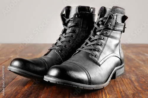 men's army boots on wooden table