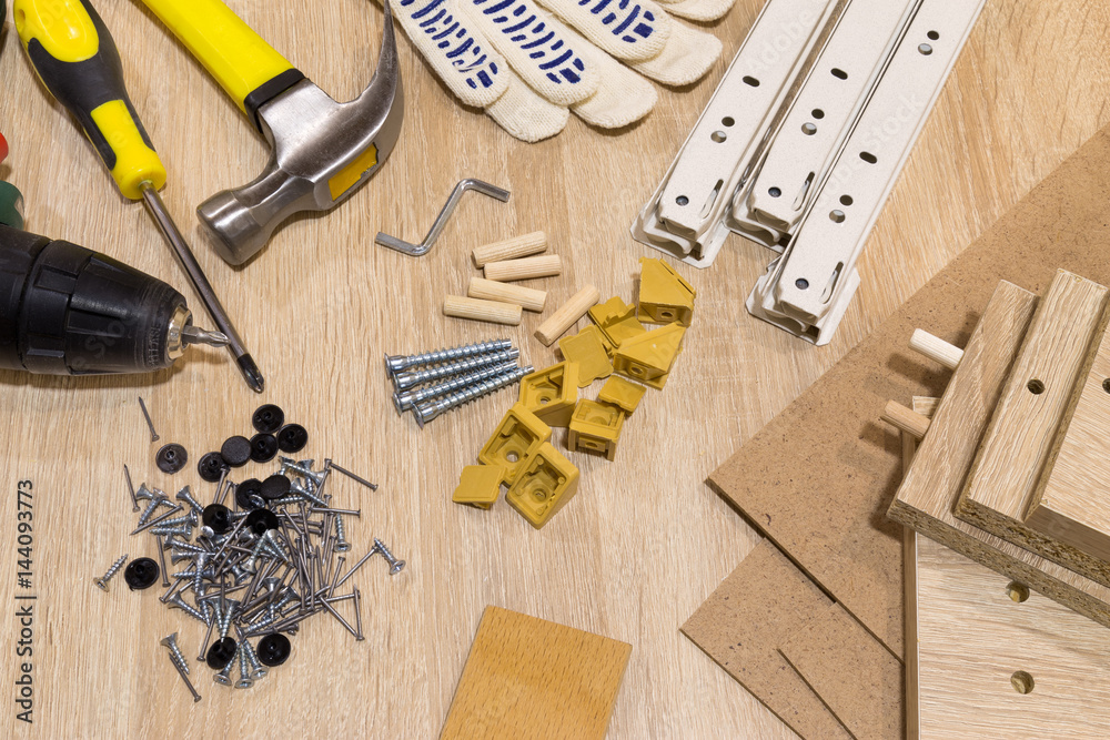 Furniture assembly components and tools arranged in a still life on a
