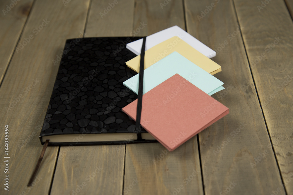 Fototapeta premium notepad with sticker on wood background
