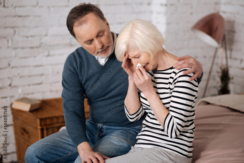 Elderly man giving solace to his sad wife Elderly man giving solace to his sad wife