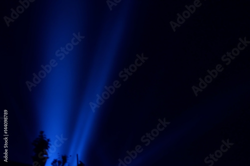 Φωτογραφία Beam of blue light on black . Applied to a searchlight torch