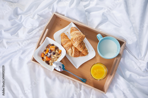 breakfast in bed with coffee and croissants. top view