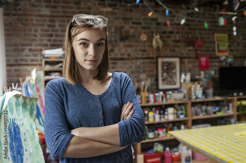 Portrait of young woman standing in studio photo