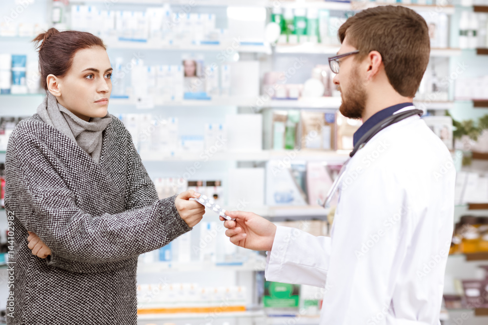 Professional pharmacist working with customers at the drugstore