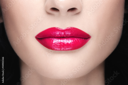 Close-up shot of woman lips with glossy fuchsia lipstick