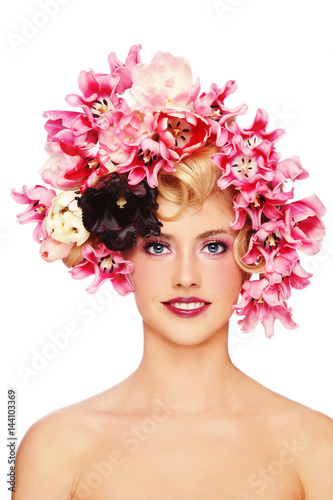 Young beautiful smiling girl with stylish make-up and colorful flowers on her hair over white background