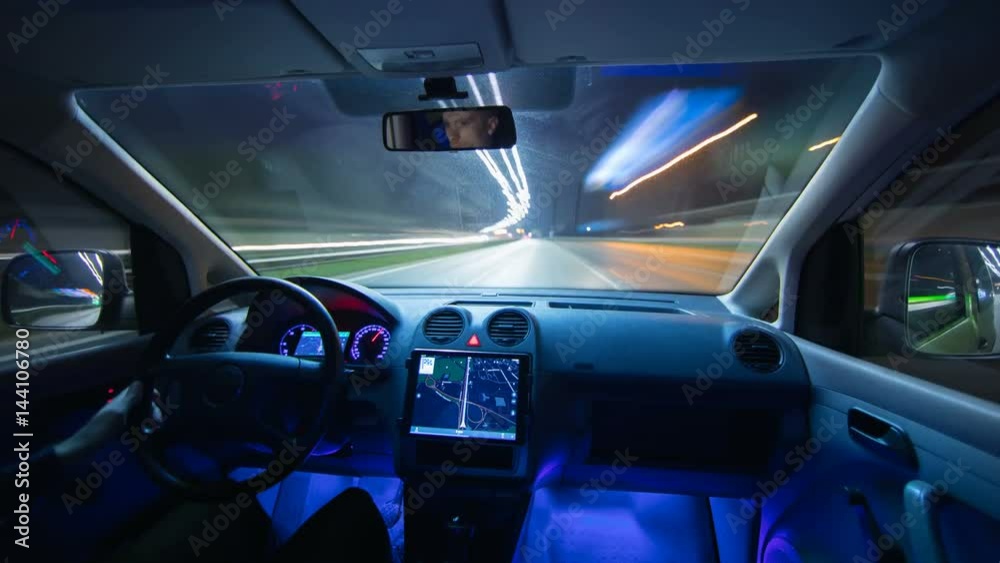 The man drive a car with a navigator in the city. Night time. Hyperlapse. Wide angle