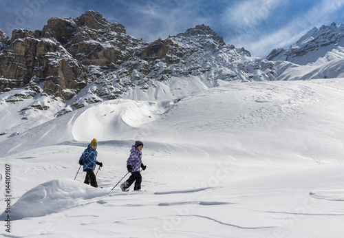 Fanes, Dolomites, South Tyrol, Italy. Children wearing snowshoes walking in the mountains of the Fanes photo