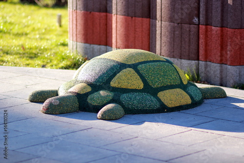 Funny green rubber turtle on children playground photo