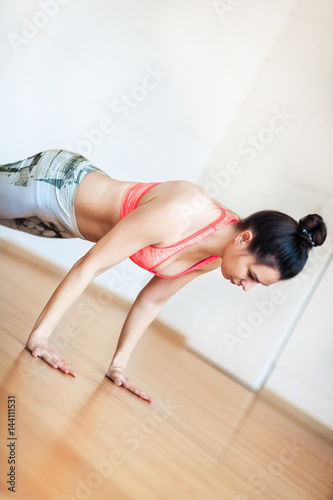 Young woman doing warm-up lying on the floor, before yoga, standing on hands