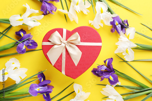 Fototapeta Naklejka Na Ścianę i Meble -  Purple and white iris flowers with gift box on yellow background